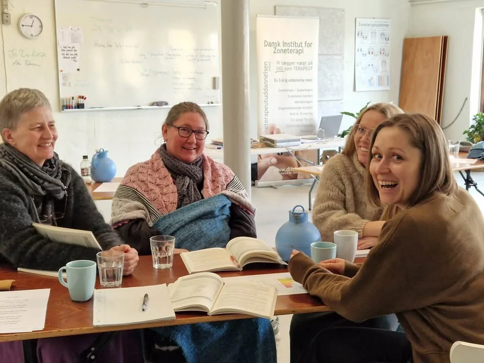 Four students around the table on the reflexology programme